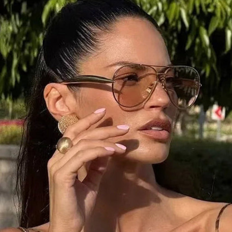 Woman wearing sunglasses and gold jewelry outdoors